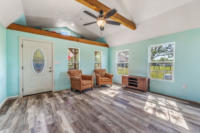 living area featuring a ceiling fan, wood finished floors, and vaulted ceiling with beams