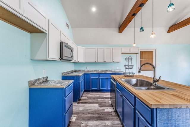 kitchen with blue cabinets, stainless steel appliances, a sink, and butcher block counters