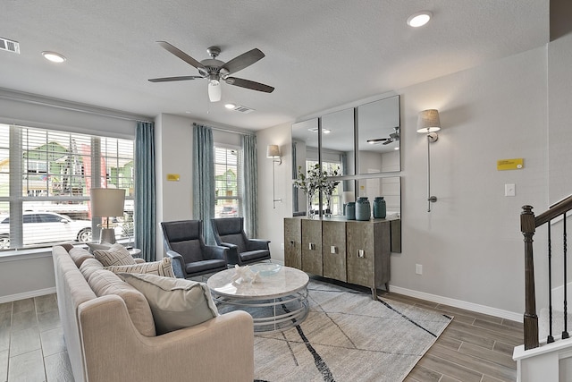 living area with ceiling fan, baseboards, stairs, and wood tiled floor