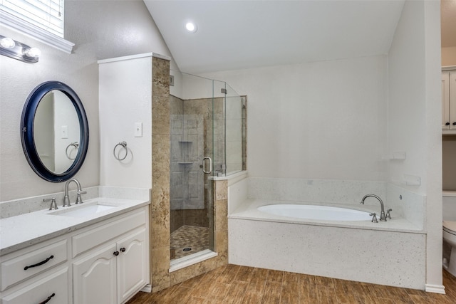 full bathroom with toilet, a stall shower, vanity, a garden tub, and lofted ceiling