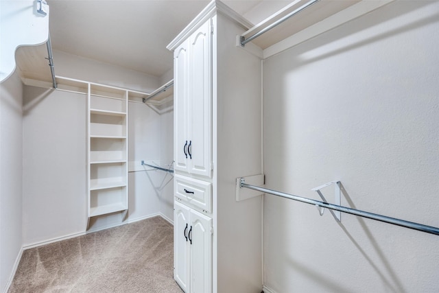 walk in closet featuring light carpet