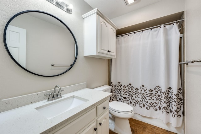 full bath with toilet, vanity, and wood finished floors