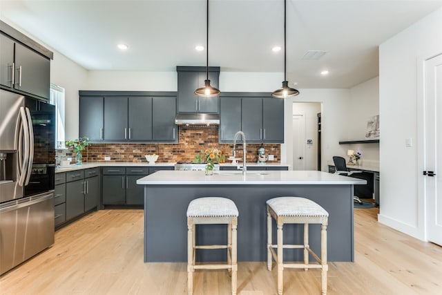 7320 Collin Mckinney Pkwy, Mckinney, TX 75070 - kitchen featuring stainless steel refrigerator with ice dispenser, light wood-style flooring, under cabinet range hood, and light countertops