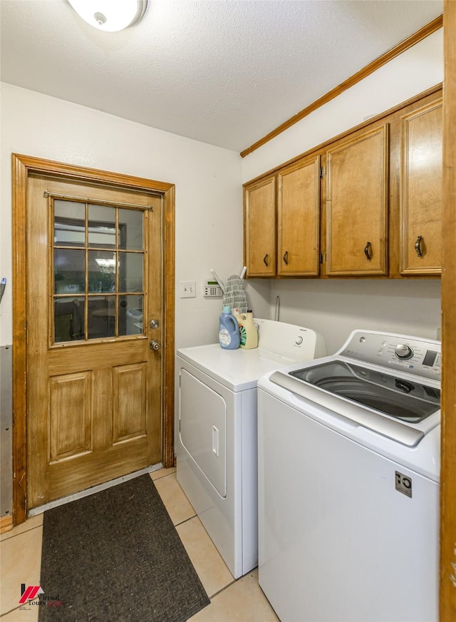 3873 Talton St, Shreveport, LA 71119 - clothes washing area with washing machine and clothes dryer, a textured ceiling, light tile patterned floors, and cabinet space