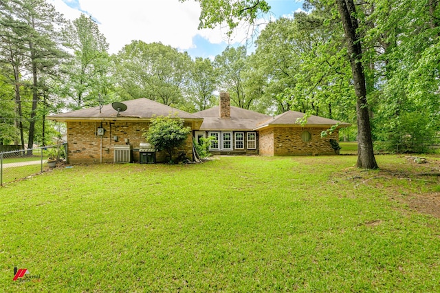 3873 Talton St, Shreveport, LA 71119 - rear view of house with a chimney, fence, a yard, central air condition unit, and brick siding