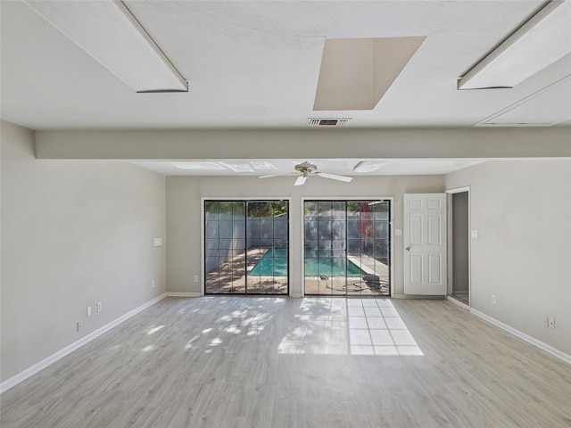 unfurnished room featuring wood finished floors, visible vents, baseboards, and ceiling fan