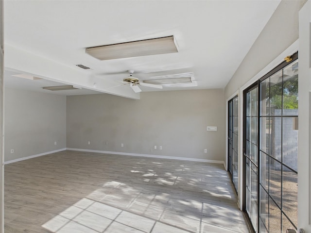 empty room featuring ceiling fan, baseboards, wood finished floors, and visible vents