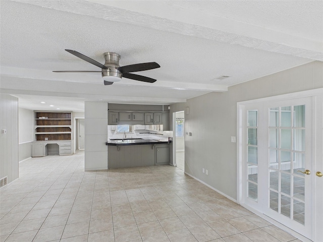unfurnished living room featuring light tile patterned floors, baseboards, a textured ceiling, and ceiling fan