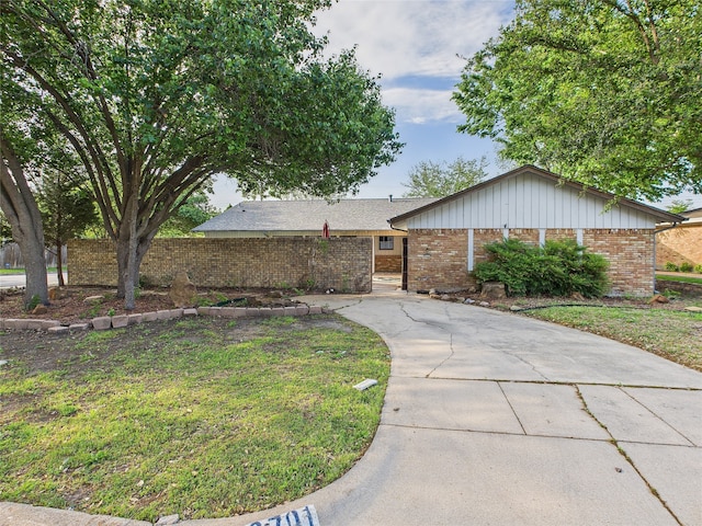 ranch-style home featuring a front lawn, driveway, and brick siding
