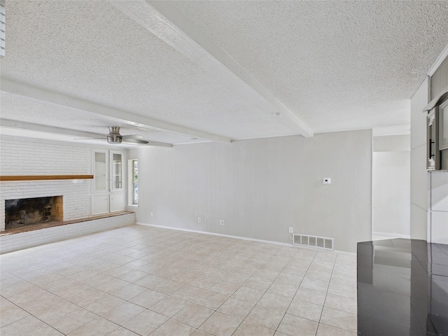 unfurnished living room with a ceiling fan, a textured ceiling, light tile patterned flooring, beamed ceiling, and visible vents