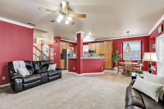 living room featuring crown molding, light carpet, stairs, a ceiling fan, and visible vents
