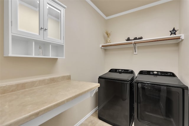 laundry area featuring ornamental molding, cabinet space, and washer and dryer