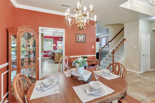 dining space featuring crown molding, light tile patterned flooring, an inviting chandelier, stairs, and visible vents