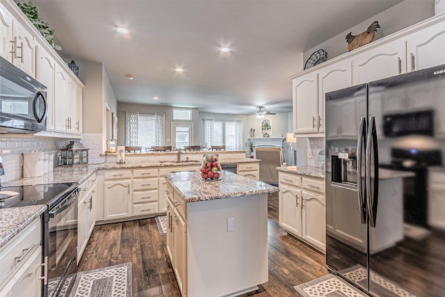 kitchen featuring a peninsula, a ceiling fan, decorative backsplash, and black appliances