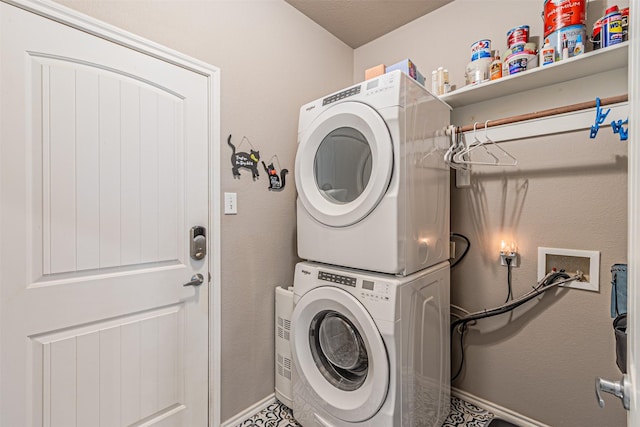 laundry room featuring baseboards, stacked washer / dryer, and laundry area