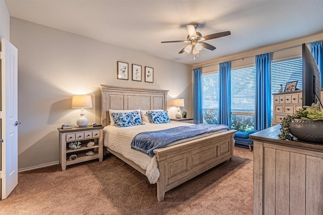 bedroom with light colored carpet, ceiling fan, and baseboards