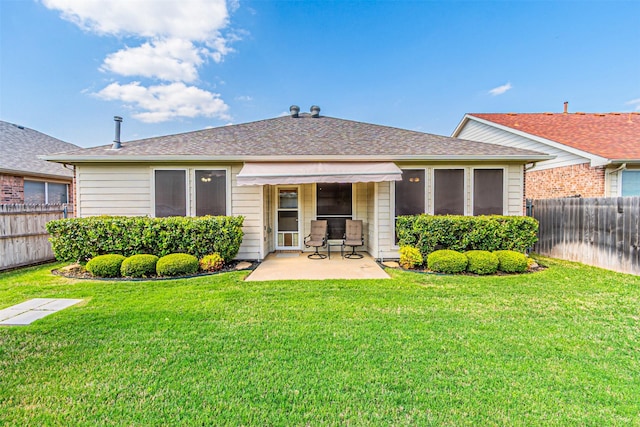 back of property featuring a patio area, a fenced backyard, roof with shingles, and a yard