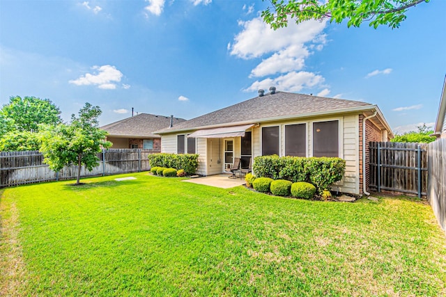 rear view of property with a lawn, a fenced backyard, and a patio
