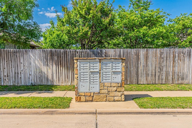 view of property's community featuring fence and mail area