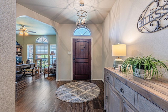 foyer featuring a healthy amount of sunlight, arched walkways, and dark wood finished floors