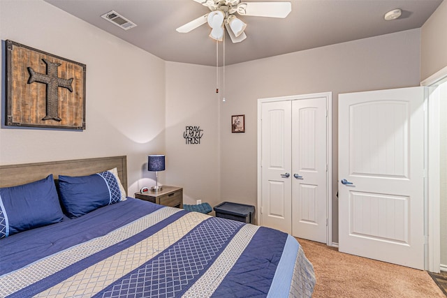bedroom with a ceiling fan, visible vents, a closet, and light colored carpet