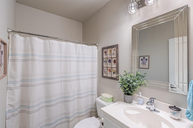 bathroom featuring a textured wall, vanity, curtained shower, and toilet