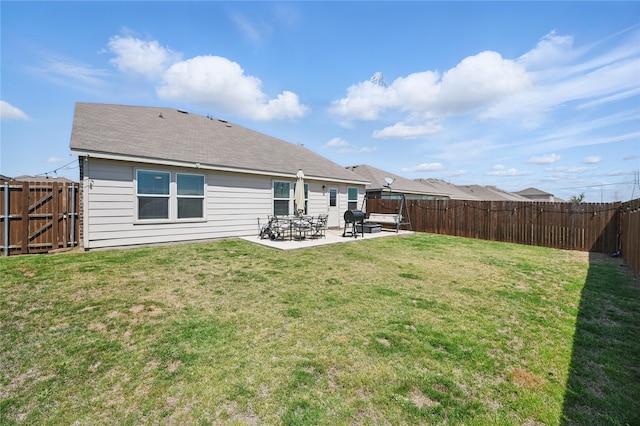 rear view of property with a yard, a patio area, and a fenced backyard