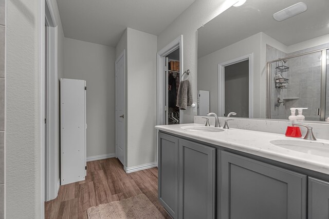 702 Grassland Way, Arlington, TX 76002 - bathroom with a tile shower, wood finished floors, and double vanity