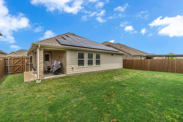 702 Grassland Way, Arlington, TX 76002 - back of property with a patio, a fenced backyard, roof mounted solar panels, brick siding, and a gate