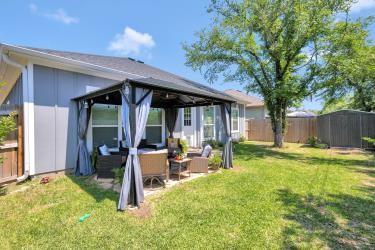 rear view of house with an outdoor living space, a lawn, a fenced backyard, and a gazebo