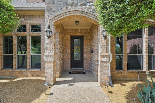 property entrance with brick siding and stone siding