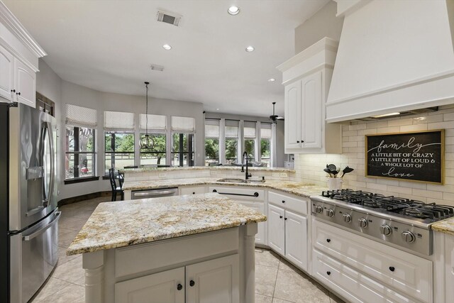 2204 Chipping Campden Rd, Denton, TX 76226 - kitchen with appliances with stainless steel finishes, premium range hood, a peninsula, a sink, and light tile patterned floors