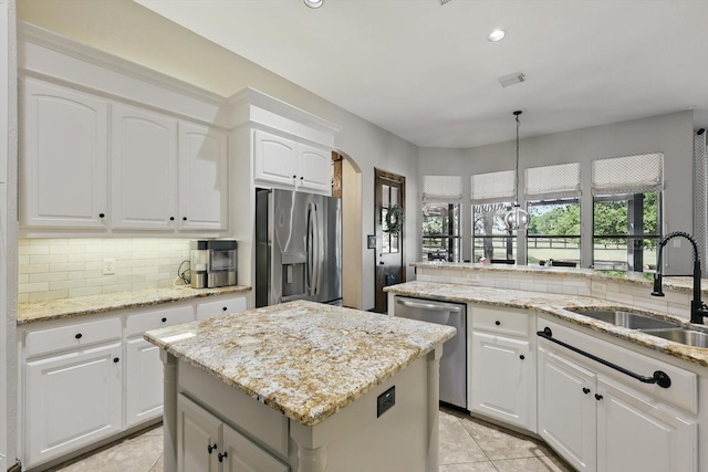2204 Chipping Campden Rd, Denton, TX 76226 - kitchen featuring appliances with stainless steel finishes, a sink, a center island, tasteful backsplash, and light tile patterned floors