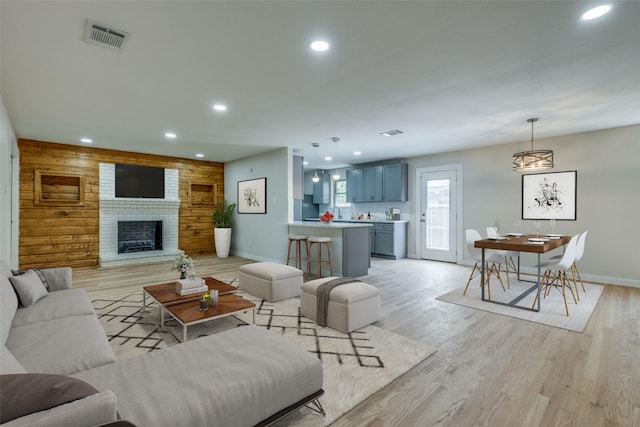 8494 Swift Ave, Dallas, TX 75228 - living room with baseboards, recessed lighting, light wood finished floors, a fireplace, and wooden walls