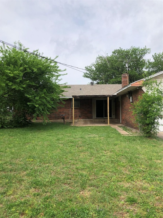 414 Brookview Dr, Desoto, TX 75115 - back of house featuring a patio area, a chimney, brick siding, and a yard