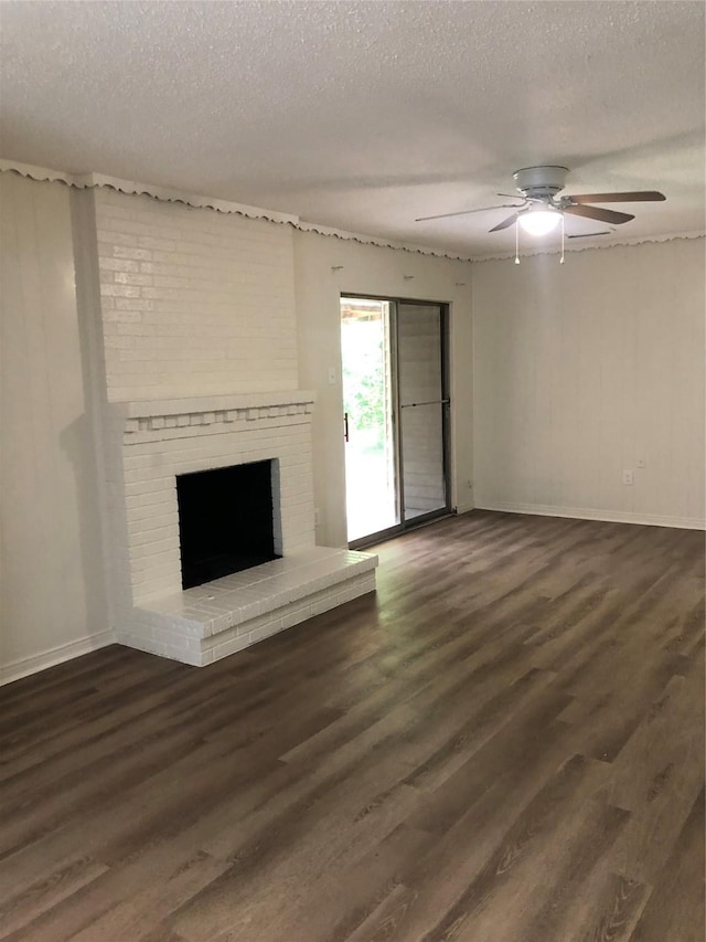 414 Brookview Dr, Desoto, TX 75115 - unfurnished living room with dark wood-type flooring, a brick fireplace, a textured ceiling, and baseboards