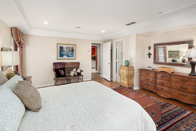 bedroom with baseboards, wood finished floors, visible vents, and recessed lighting