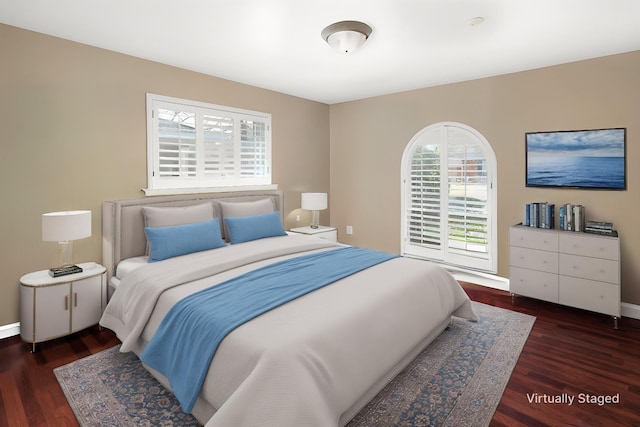 bedroom with baseboards, wood finished floors, and multiple windows