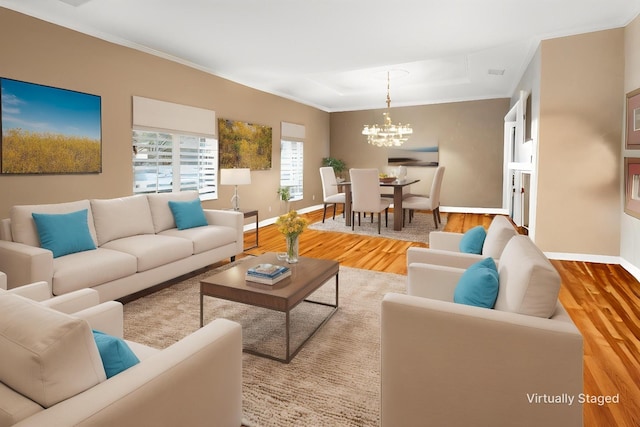 living room with baseboards, a notable chandelier, and wood finished floors