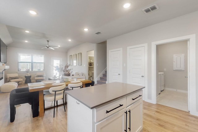 kitchen with separate washer and dryer, open floor plan, a ceiling fan, and visible vents