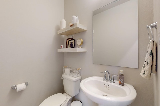 half bath featuring toilet and a sink