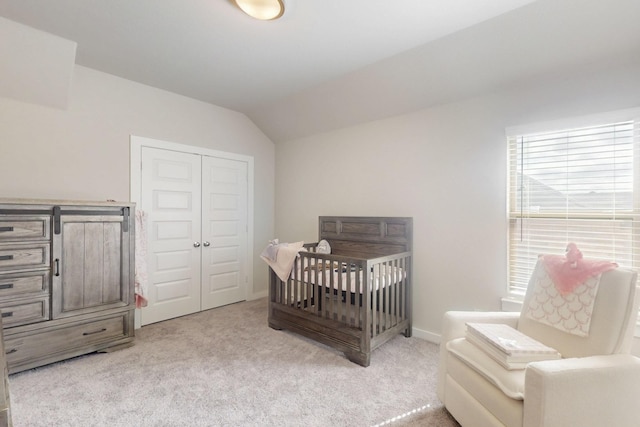 bedroom with lofted ceiling, carpet, and a closet