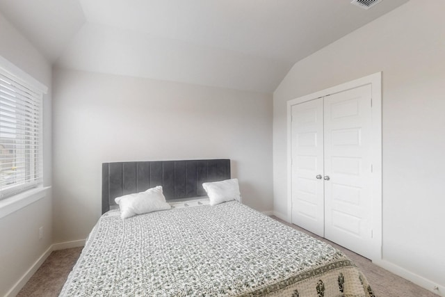 bedroom featuring vaulted ceiling, carpet floors, baseboards, and a closet