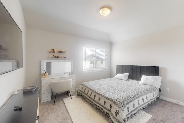 bedroom featuring vaulted ceiling and light carpet