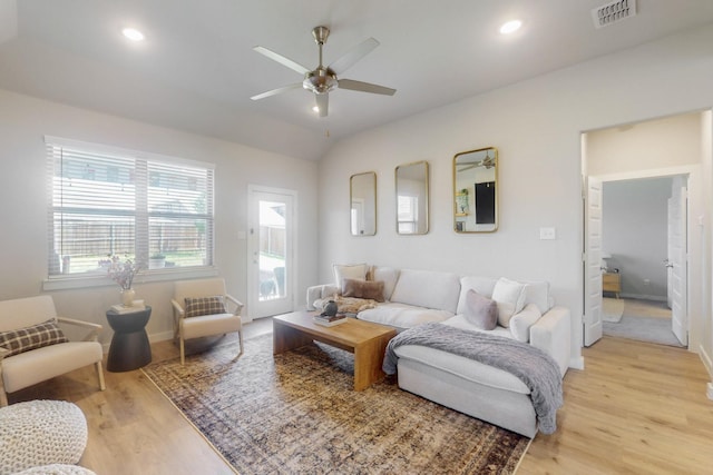 living room with light wood finished floors, visible vents, baseboards, and a ceiling fan