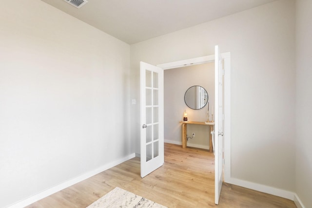 interior space featuring baseboards, french doors, and light wood-style flooring
