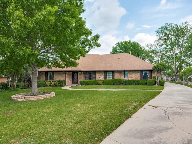 single story home featuring brick siding, roof with shingles, and a front lawn