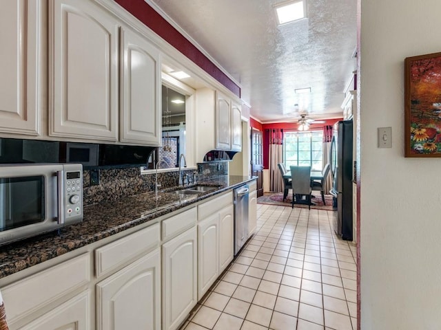 kitchen with white cabinetry, appliances with stainless steel finishes, a ceiling fan, and a sink