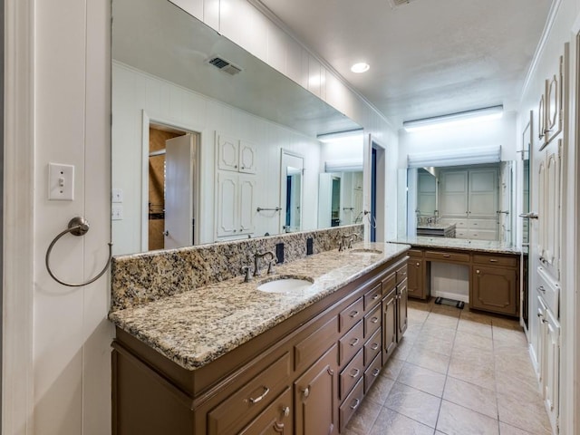 full bath with tile patterned flooring, visible vents, a sink, and double vanity