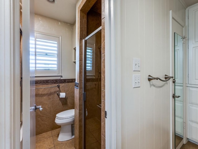 full bath featuring tile walls, tile patterned floors, a stall shower, and toilet
